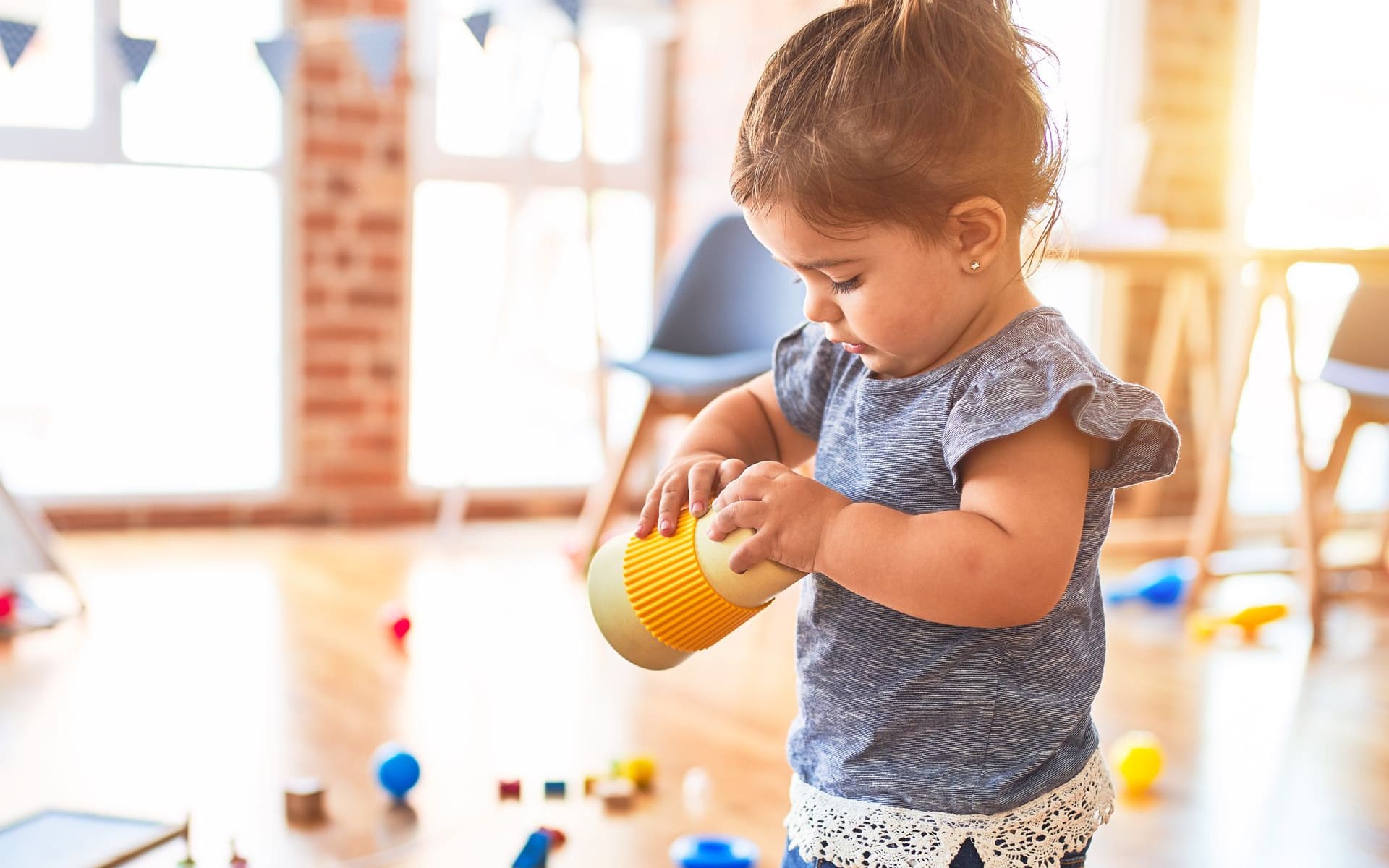 Toddler playing with toys in a bright, sunlit family day care home