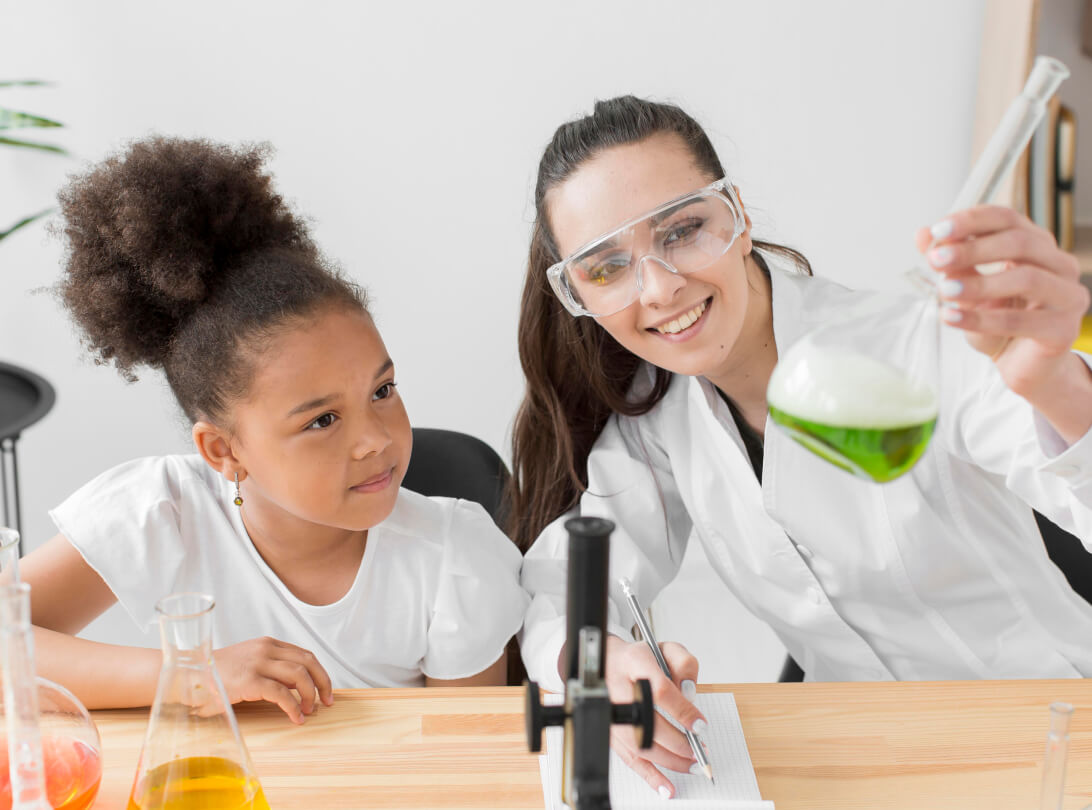 Child doing a science experiment with an educator
