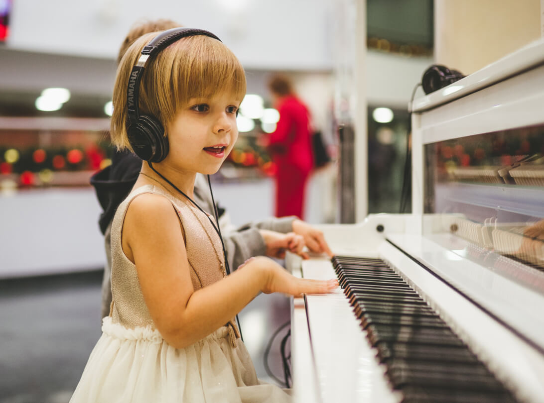 Child playing piano with headphones