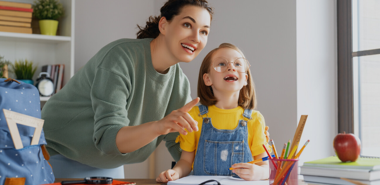 Educator helping a child with schoolwork at a desk